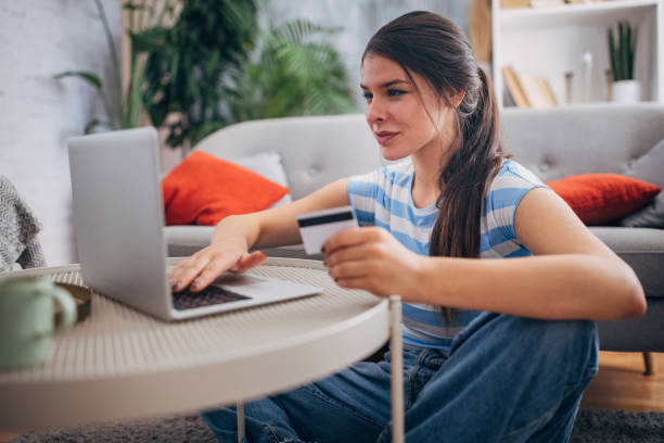 istock Woman using laptop, smiling, and holding a card. 2169450908