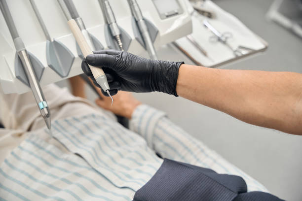 istock Male dentist uses modern equipment at work 2169451668
