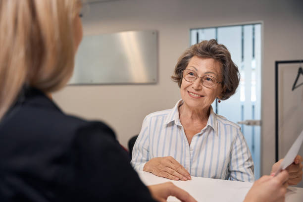 istock Young blonde offers elderly lady to fill out questionnaire 2169451886