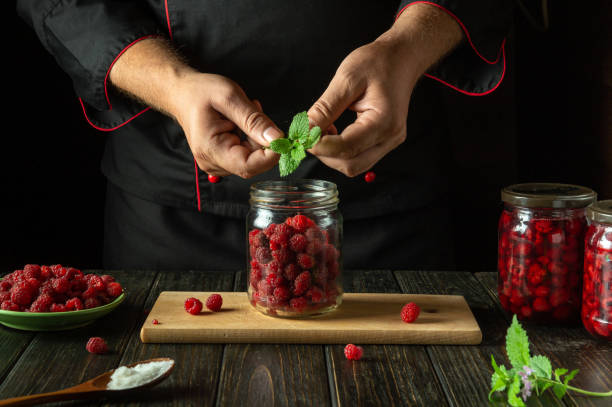 istock Chef hands adding aromatic green mint to a jar of raspberries before canning. Concept of making delicious compote from sweet raspberry 2169453060
