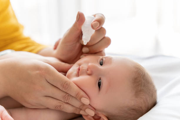 istock Mother dripping nasal drops for her infant at home 2169453381