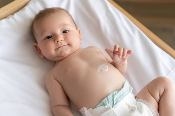 istock Newborn baby lying on bed with cream on his tiny baby 2169453419