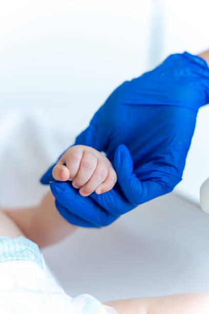 istock Pediatrician examining baby holding tiny finger 2169453559