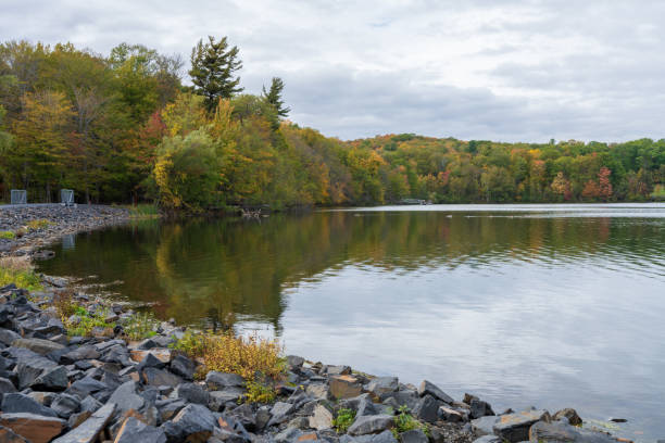 istock Fall foliage forest reflected on Moulin Lake. Mont-Saint-Bruno National Park, Saint-Bruno-de-Montarville, Quebec, Canada. 2169457781