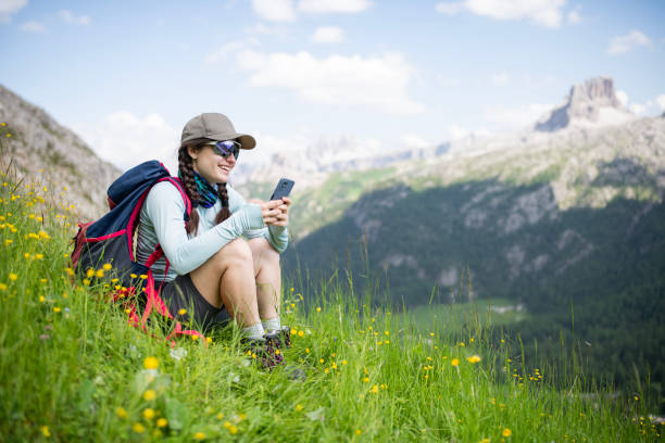 istock Woman on a hike sitting and using phone while resting. 2169458409