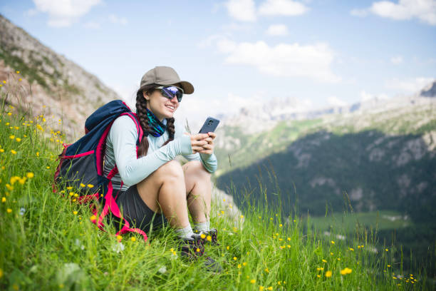 istock Woman on a hike sitting and using phone while resting. 2169458411