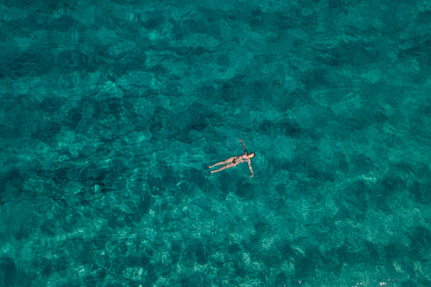 istock Woman floating on turquoise sea. 2169458418