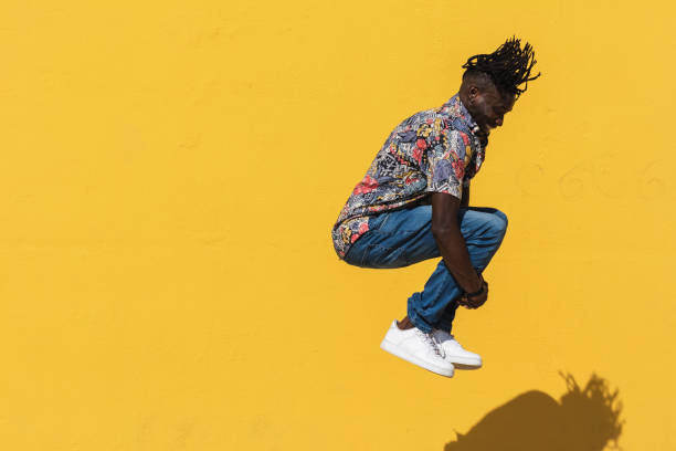 istock Energetic black man jumping near yellow wall 2169458687