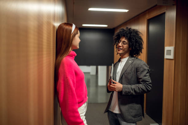 istock Two young people talking in the corridor and looking involved 2169459245