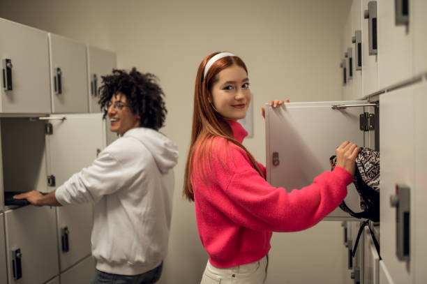 istock Two young people standing near the lockers and talking 2169459247