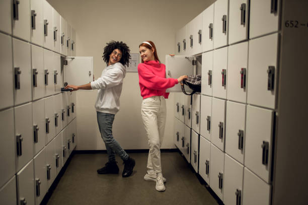 istock Two young people standing near the lockers and talking 2169459253