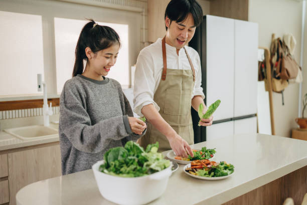 istock Couple preparing food together at kitchen 2169462695