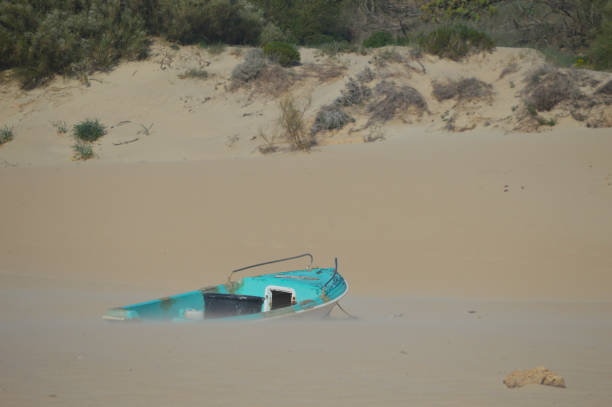 istock Blue boat in a dune in the beach 2169464163
