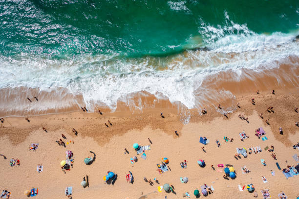 istock Overhead drone view of anonymous tourists and parasols on sandy shore 2169469201