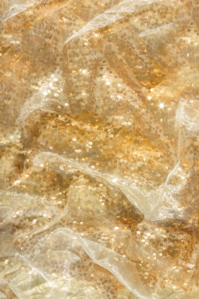 istock Gold sequin background with white silk folds on top. 2169471820