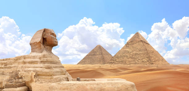 Famous Great Sphinx and pyramids of Chephren and Cheops, Cairo, Egypt. Great Pyramids and ancient statue of Sphinx, mythical creature with head of man and body of lion, Giza complex (Giza Necropolis)