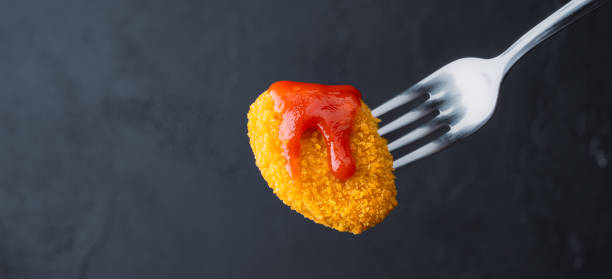 istock Delicious chicken nuggets on black background. Cooked or raw chicken nuggets 2169484401