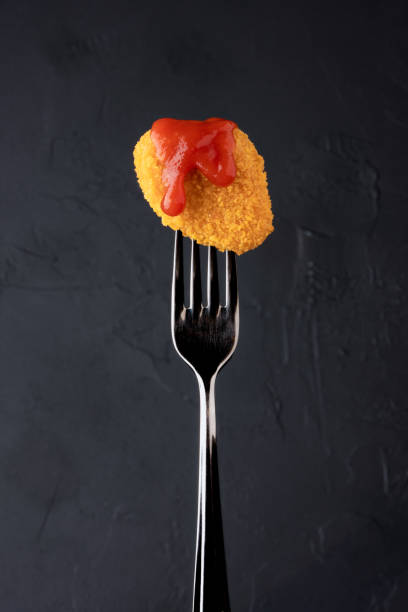 istock Delicious chicken nuggets on black background. Cooked or raw chicken nuggets 2169484402
