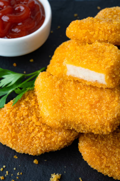 istock Delicious chicken nuggets on black background. Cooked or raw chicken nuggets 2169484558