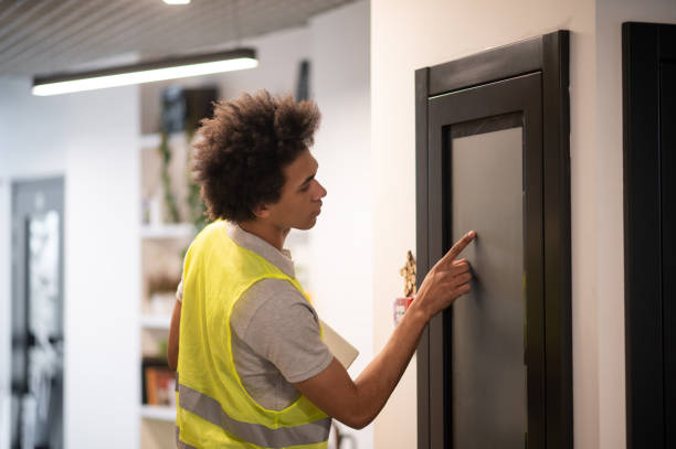 istock Dark-skinned serviceman checking the office doors locker after working day 2169485175