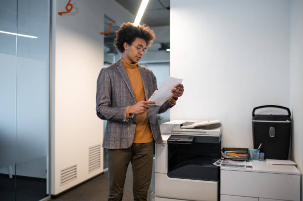 istock Young man putting the documents in the file and looking involved 2169485206