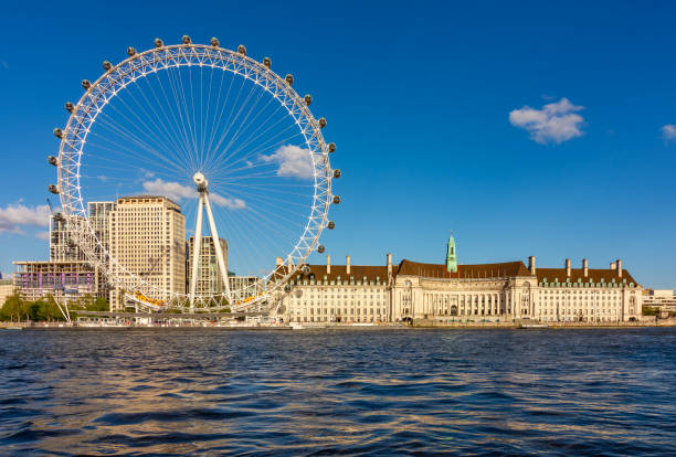 London, UK - 29 April 2024: London Eye (Millennium Wheel) and County Hall building along Thames river