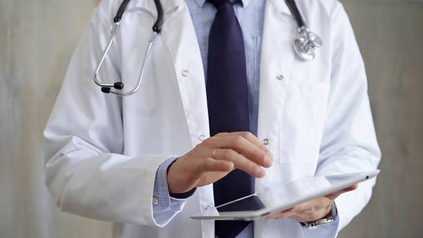 istock Doctor man wearing lab coat and stethoscope using tablet computer in hospital. Medicine and science 2169488280