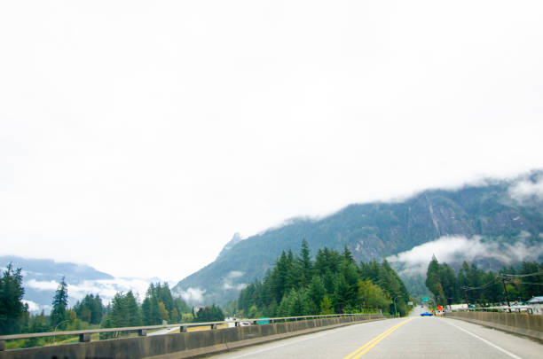 Highway in Hope  BC, Canada with cloud covered mountains in the background