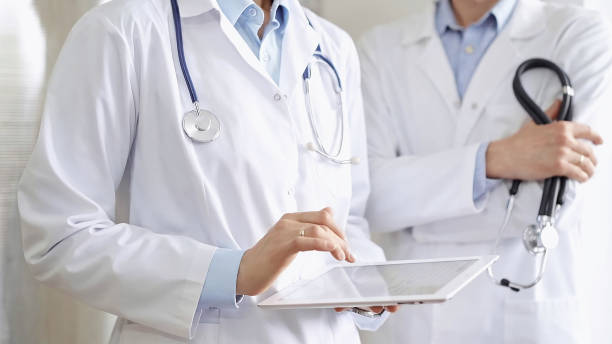 istock Two doctors wearing white coats and stethoscopes, using a digital tablet, discussing a patient's medical history. Medicine and science 2169489531