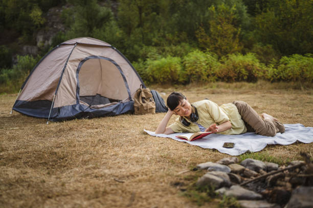 istock Mature japanese woman lying down on a ground and read a book 2169493191