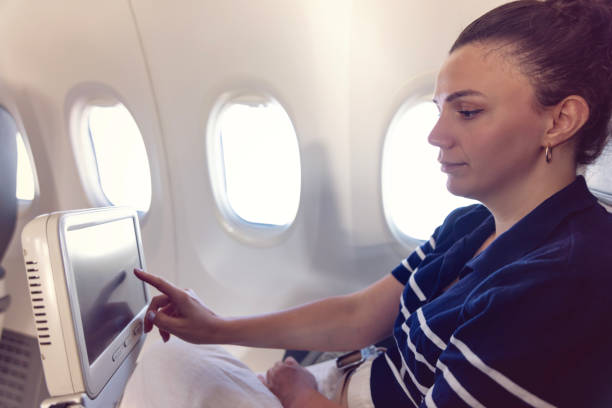 istock Young woman on airplane using on board entertainment 2169497248