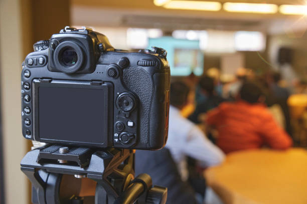 istock A camera is pointed at a group of people sitting at a table 2169499700