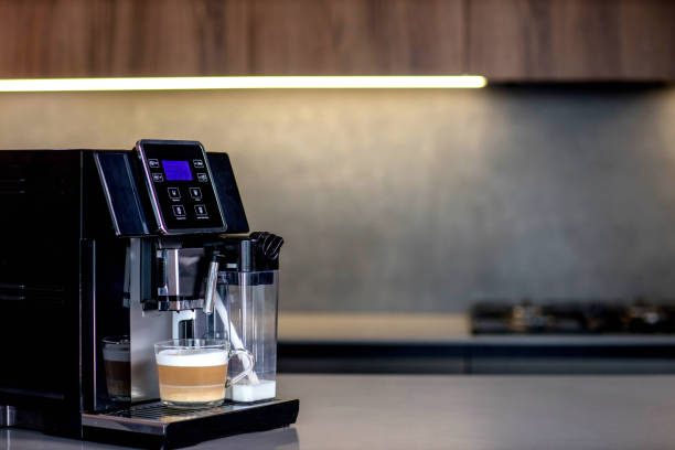 istock Modern coffee machine with glass cup of latte in kitchen 2169505351