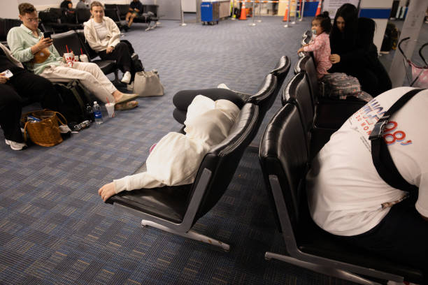 Dulles, Virginia, USA - July 9, 2024 - A traveler sleeps at the gate while waiting on a delayed flight