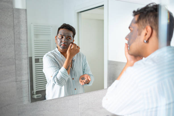 istock Man applying face mask in bathroom mirror 2169519536