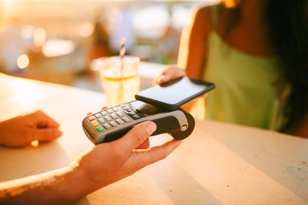 istock Woman making a mobile payment at a bar 2169519810