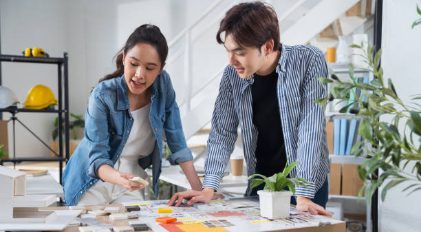 istock Asian business startup team architects working project in office convene in a modern coworking office. Asian team architect designing a house plan, Interior choosing tiles for a residential project 2169522580