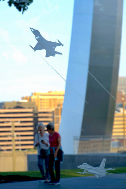 Arlington, Virginia, USA - August 23, 2024:  Two women visiting the U.S. Air Force Memorial are seen through an etched depiction of an F-16 missing man formation.