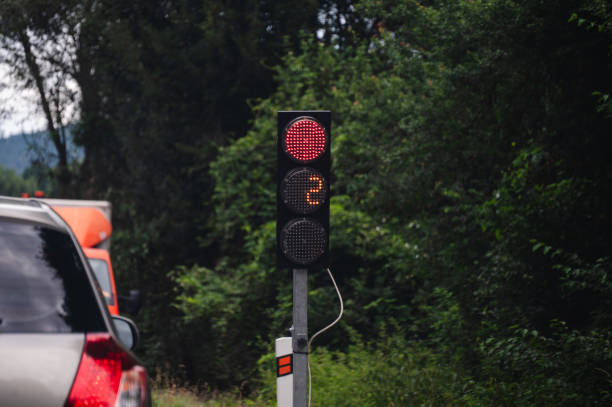 Driving at dusk, stop sign, red traffic lights, rear view of car waiting, tail lights. Galicia, Spain.