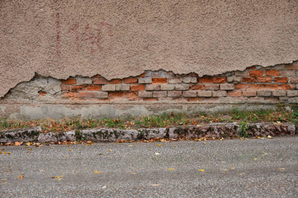 A detailed view of a textured plaster wall featuring earthy, warm tones. The rough surface and subtle variations in color give the wall a rustic and natural appearance, evoking a sense of aged craftsmanship.
