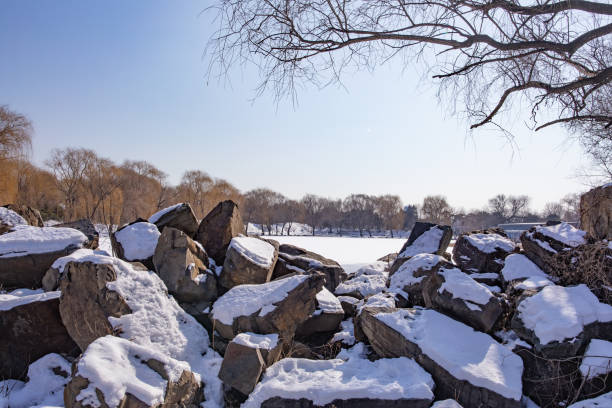 Old summer palace in a cold winter day with the melting snow on the rocks and ice on the lake