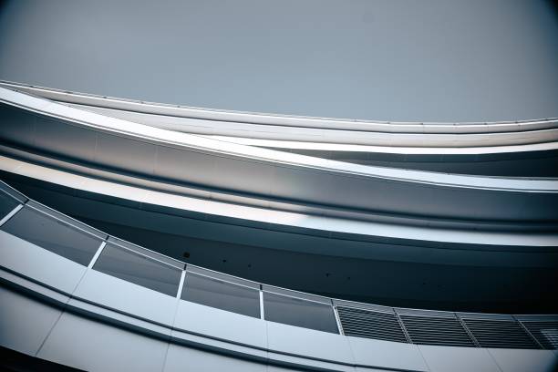 istock Modern architecture with a curved design, showcasing white panels and a sleek metal railing. 2169531500