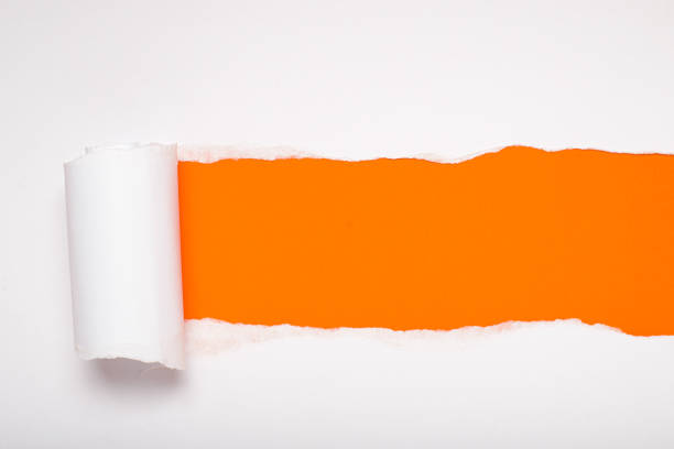 istock Torn white paper revealing a orange background. Space for text. 2169532070