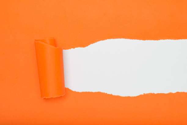 istock Torn orange paper revealing a white background. Space for text. 2169532091