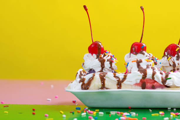 A plate with ice cream, exotic fruit, whipped cream and syrup.