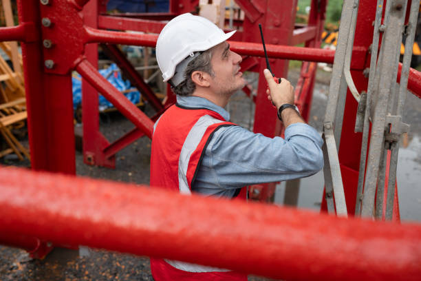 istock Caucasian mature engineer man worker use walkie talkie working with spare crane background 2169534021