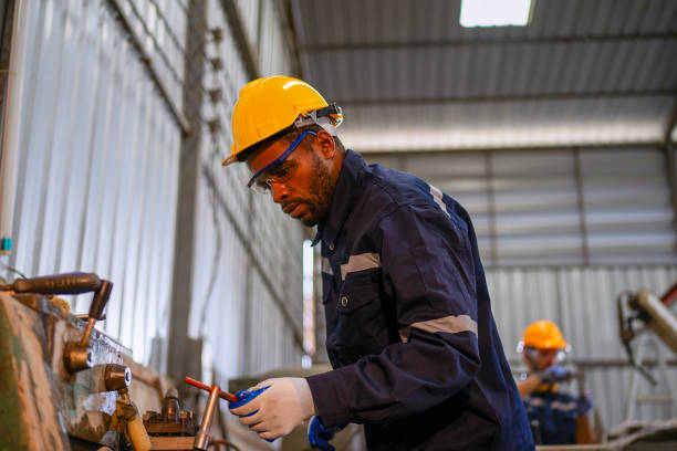 istock Blue collar workers at machine shop with welding robot arm. 2169536336