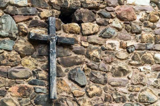 istock Wooden old cross hanging on a stone wall 2169538003