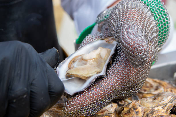 istock Fresh oysters being cleaned by hand in chainmail glove 2169539681