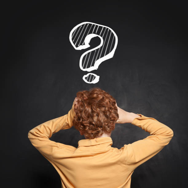 istock Frightened kid school student and question mark on blackboard. Idea and Education concept 2169541370